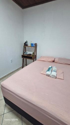 un letto con due paia di sandali sopra di Refúgio baiano Ilhéus WI-FI a Ilhéus