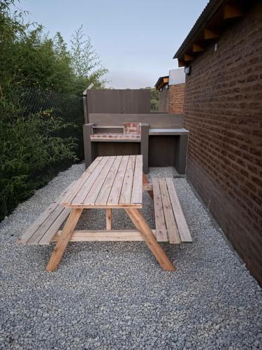 ein hölzerner Picknicktisch neben einer Backsteinmauer in der Unterkunft Freedom in Miramar