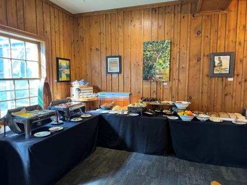 una stanza con due serie di tavoli con cibo di Sherwood Inn a Port Carling