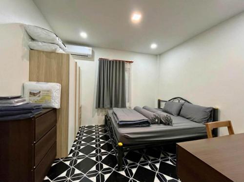 a small room with a bed in a room with a table at Wanderlust Cove in Wok Tum