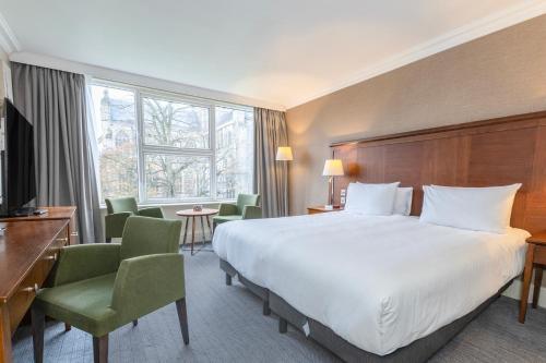 a hotel room with a large bed and chairs at Winchester Wessex Hotel by Sunday in Winchester