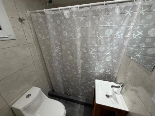 a bathroom with a shower curtain and a toilet at Freedom in Miramar