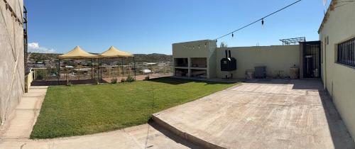 een gebouw met een tuin met een gazon en parasols bij El Cerrito in Las Heras