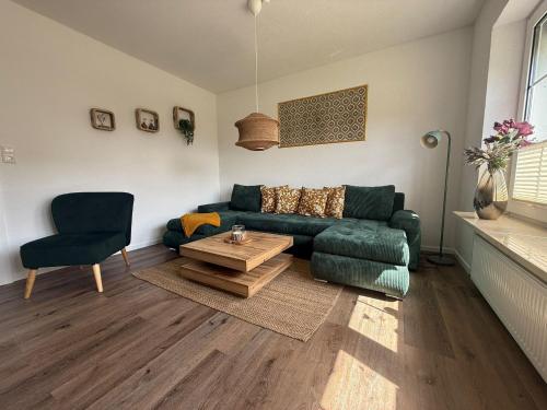 a living room with a green couch and a table at Huus Christine in Holtgast