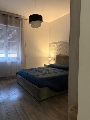 ein Schlafzimmer mit einem Bett mit einer blauen Bettdecke in der Unterkunft Di Giuseppe Laura in Ladispoli