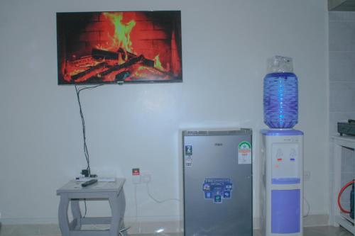 een kamer met een tv en een vuur in de muur bij Luxe Homes in Meru