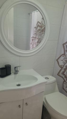 a bathroom with a sink and a mirror and a toilet at casa reñaca sector jardín del mar in Viña del Mar