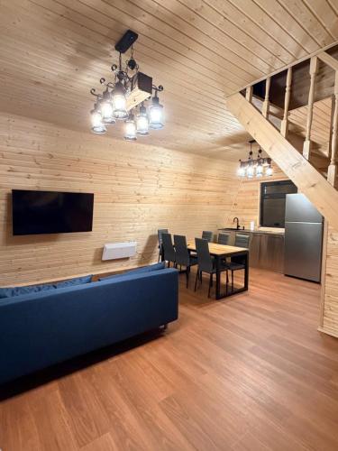 een woonkamer met een tafel en stoelen en een televisie bij WinterFell Mestia in Mestia