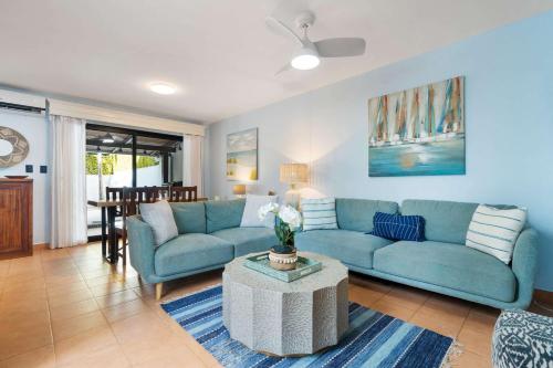 a living room with a blue couch and a table at Spacious Home with Private Pool & Covered Patio Near the Beach in Playa Flamingo