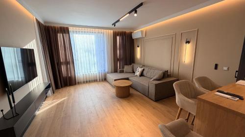 ein Wohnzimmer mit Sofa und Fernseher in der Unterkunft Lux Living Apartments in Plowdiw