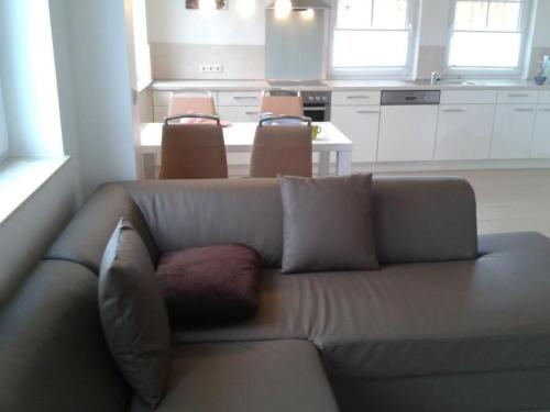 a living room with a couch and a kitchen at Apartment 4 by Interhome in Feldhusen