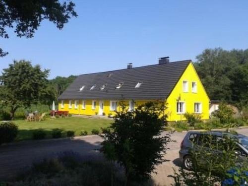 a yellow house with a black roof at Apartment 4 by Interhome in Feldhusen