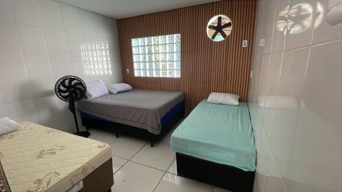 een kleine kamer met twee bedden en een raam bij Casa Cacau in Ubatuba
