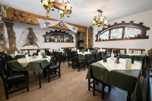 una sala da pranzo con tavoli e sedie verdi di Pensiunea Crocus - Sauna & Billiard a Poiana Brasov