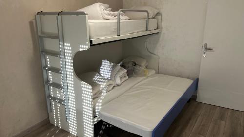 een kleine kamer met een stapelbed en een plank bij Chambre Pour collocation in Thionville