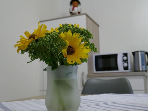 a vase filled with yellow flowers sitting on a table at Apartment Im Hof by Interhome in Pittenbach