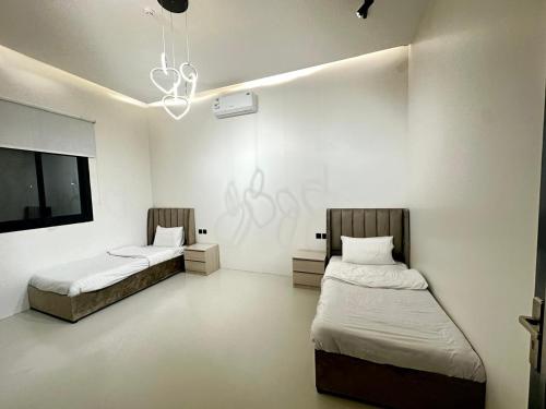 a room with two beds and a tv in it at شاليهات ريف الوادي in Taif