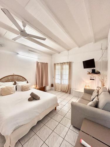 a large bedroom with a bed and a couch at Gîte Hibiscus Destrellan in Baie-Mahault