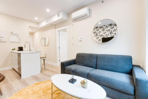 ein Wohnzimmer mit einem blauen Sofa und einem Tisch in der Unterkunft Mont Royal Suites - M11 in Montreal