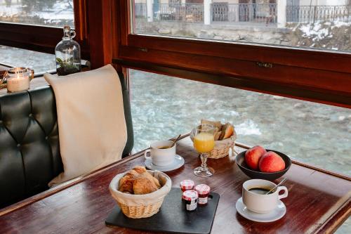 einen Tisch mit zwei Tassen Kaffee und einer Schale Obst in der Unterkunft Hôtel Vallée Blanche in Chamonix-Mont-Blanc