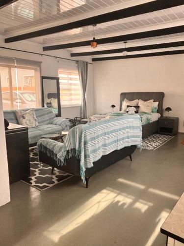a bedroom with a bed and a couch at Cape Comfy Hidden Home in Cravenby