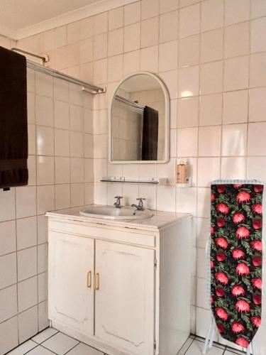 a white bathroom with a sink and a mirror at Cape Comfy Hidden Home in Cravenby