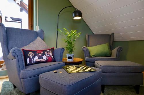 een woonkamer met twee blauwe stoelen en een schaakbord bij Bühler Blick in Bühl