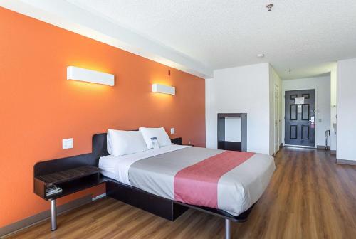 a large bed in a room with an orange wall at Motel 6-Williams, AZ - West - Grand Canyon in Williams