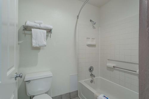 a white bathroom with a toilet and a bath tub at Motel 6-Williams, AZ - West - Grand Canyon in Williams