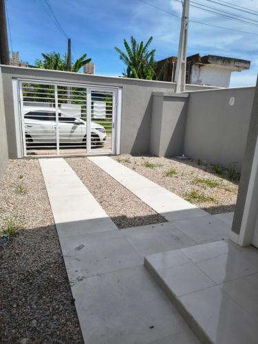 a driveway with a gate in front of a house at Casa Jardim dourado in Porto Belo