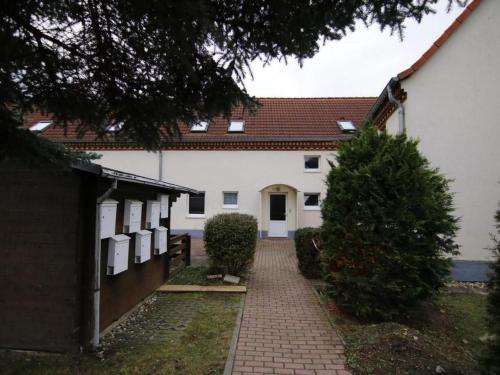 a white house with a red roof and a driveway at Apartment Urlaubszuhause by Interhome in Naundorf