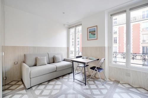 een woonkamer met een bank en een tafel bij Studio cosy - 2P - Bercy in Parijs