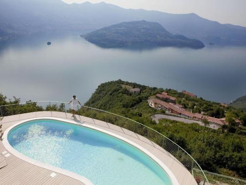 a person standing on the edge of a swimming pool overlooking a lake at Apartment 'Cezanne by Interhome in Parzanica
