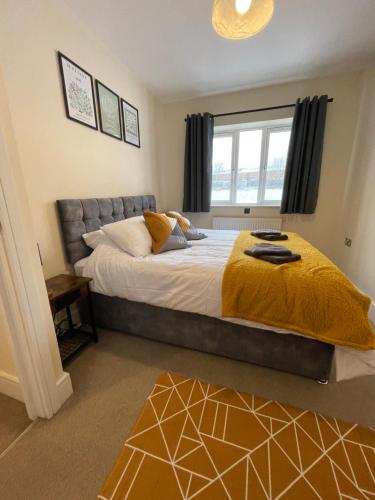 una camera da letto con un grande letto con una coperta gialla di 4 bed house perfect for contractors a Coseley