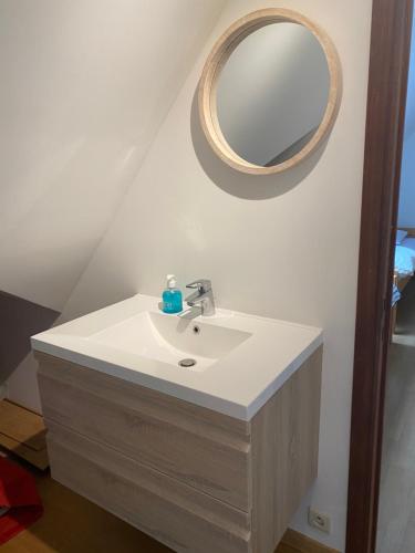 un lavandino del bagno con uno specchio sul muro di Nivekerke 8 Nieuwmunster De Haan, 3-bedroom holiday house for 4 to 6 people, between Wenduine, 1 km, and De Haan, 2 km, 500 meters from the beach,15 min from Bruges, Ostend and Knokke, fenced garden, bed linen and towels provided, pet allowed, on demand a Zuienkerke