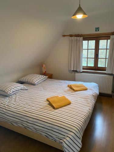 una camera da letto con un letto con due asciugamani sopra di Nivekerke 8 Nieuwmunster De Haan, 3-bedroom holiday house for 4 to 6 people, between Wenduine, 1 km, and De Haan, 2 km, 500 meters from the beach,15 min from Bruges, Ostend and Knokke, fenced garden, bed linen and towels provided, pet allowed, on demand a Zuienkerke