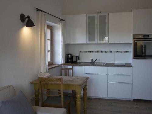 a kitchen with white cabinets and a wooden table at Apartment Apartment - Monteure by Interhome in Emmering