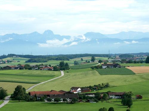 a village in a green field with mountains in the background at Apartment Apartment - Monteure by Interhome in Emmering