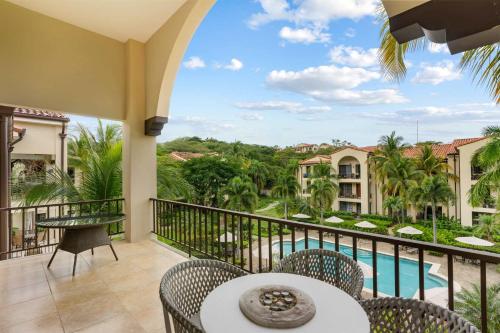 a balcony with a table and chairs and a pool at Elegant Condo in High-End Resort Community with Pool and Beach Club Access in Coco