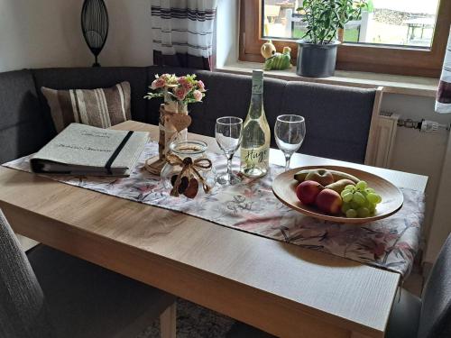 a table with a bowl of fruit and wine glasses at Apartment FeWo Steinbeisser by Interhome in Arrach