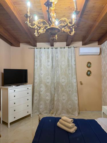 a bedroom with a chandelier and a bed and a tv at B&B temptation in CTA