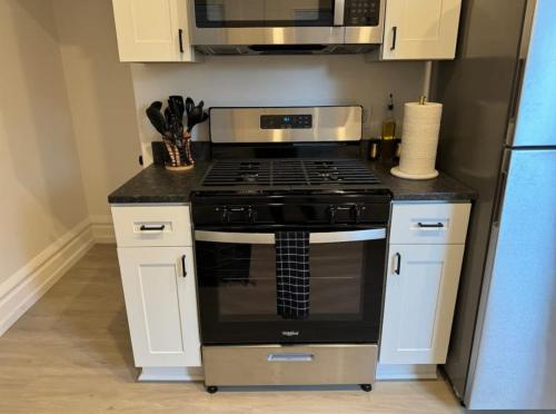 een keuken met een fornuis en een magnetron bij Jungle House Columbus Short North Downtown Free Parking - Near Convention Center & Nationwide Arena - 4BR Luxury Home - Sleeps 12 - Over 5,800 Five Star Stays in Columbus