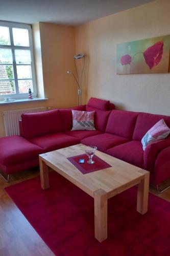 a living room with a red couch and a coffee table at Apartment Mooij Plaats by Interhome in Großefehn 