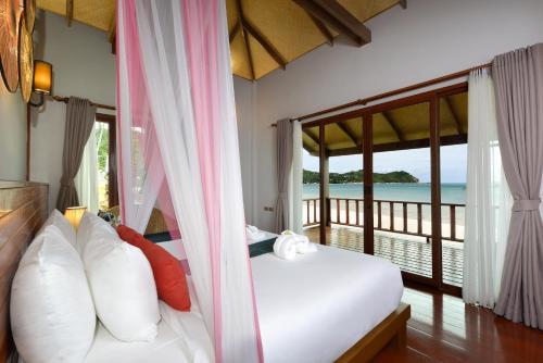 a bedroom with a bed with a view of the ocean at PingChan Koh Phangan Beachfront Resort in Thong Nai Pan Yai