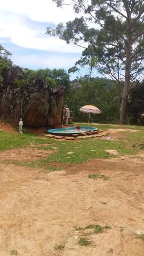 een parasol en een zwembad in een veld bij Caveira oficiall in Mairiporã