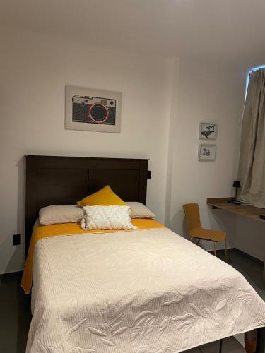 a bedroom with a bed with a yellow pillow at Stylish Condo Steps to Beach & Malecón in Mazatlán