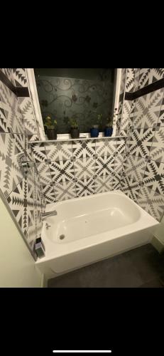 a white bath tub in a bathroom with tiles at Must-See Okemo Mountain Resort in Springfield