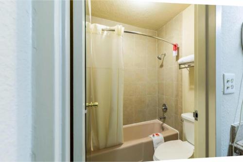 a bathroom with a tub and a toilet and a shower at Regency Inn & Suites Houston East I 10 in Houston