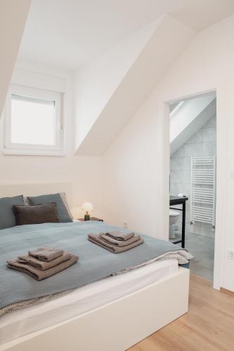 a white bedroom with a bed with towels on it at Vanjkuš in Marija Bistrica
