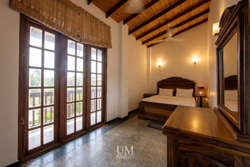 een slaapkamer met een bed en grote ramen bij Epic Unawatuna in Unawatuna